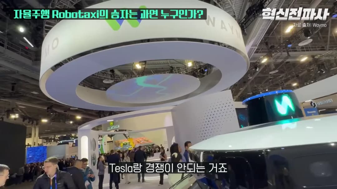 전시회장에 설치된 웨이모 로고가 새겨진 대형 원형 조형물과 자율주행 차량의 모습.