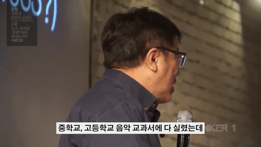 안경을 쓴 남성이 마이크를 잡고 강연하는 옆모습이 담긴 영상 캡처 화면