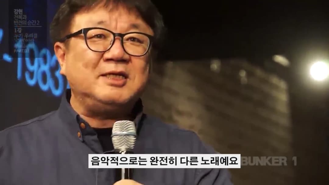 안경을 쓴 중년 남성이 마이크를 잡고 강연하는 모습이 담긴 영상 화면