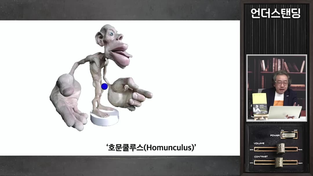 손과 입술이 비정상적으로 큰 기괴한 모습의 호문쿨루스 모형이 화면에 나타나 있다.
