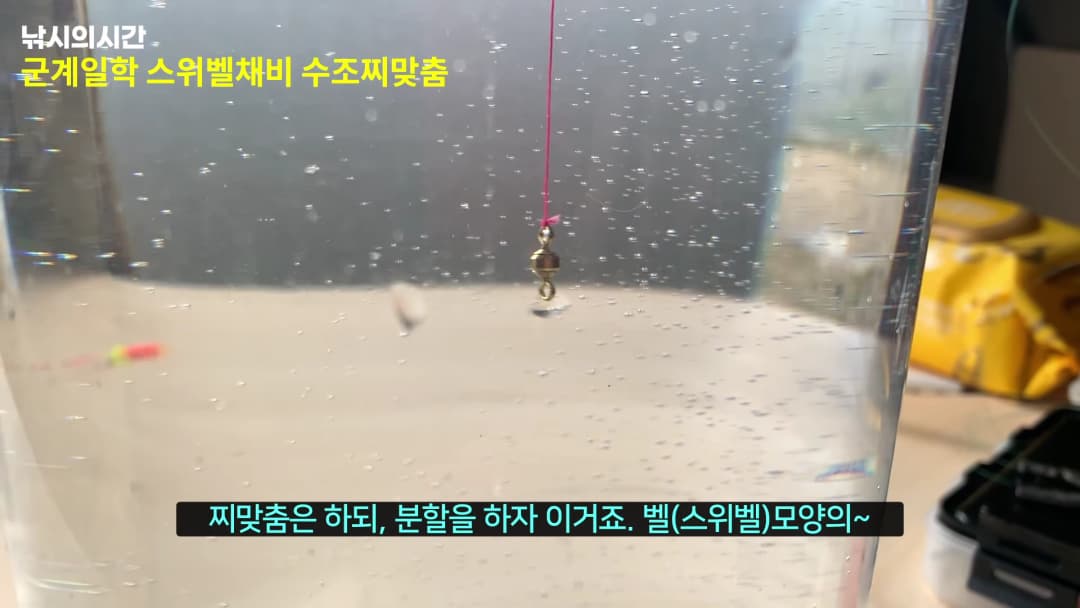 투명한 수조 속에 낚싯줄에 매달린 스위벨 채비가 떠 있는 모습