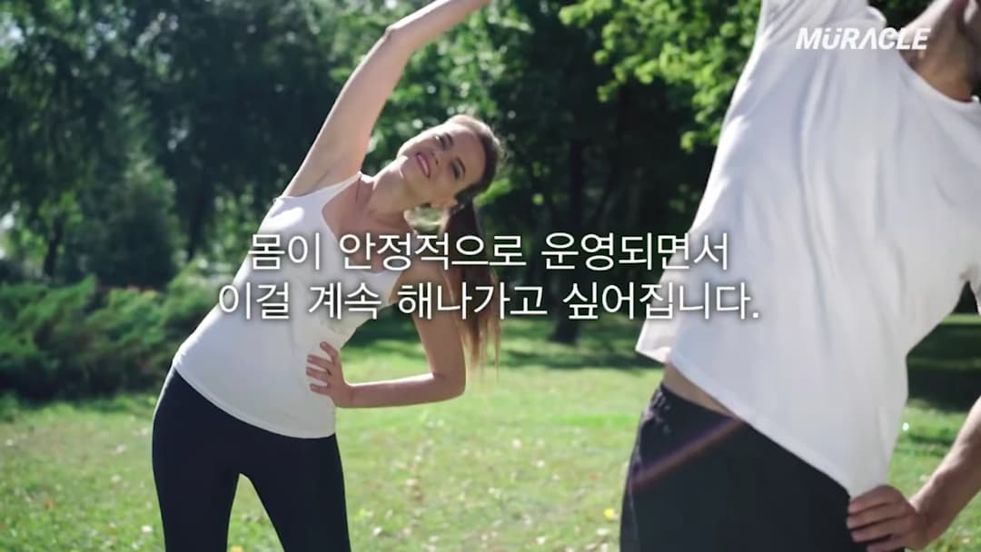 야외 공원에서 운동복을 입고 스트레칭을 하는 남녀와 화면 중앙에 적힌 한국어 자막
