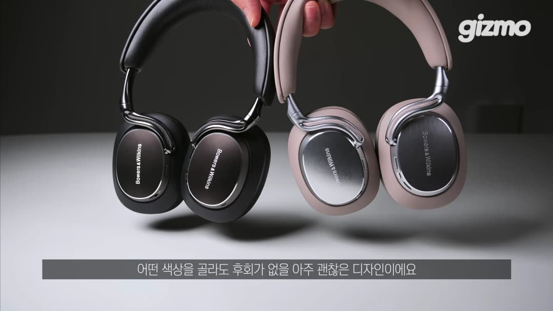 손으로 들고 있는 블랙과 웜스톤 색상의 바워스앤윌킨스 헤드폰 두 대